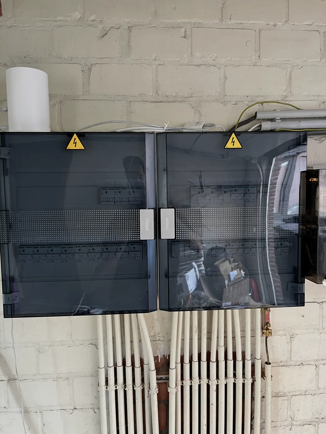 Twee nieuwe verdeelkasten boven verwarmingsleidingen in kelder, geplaatst door Wattra