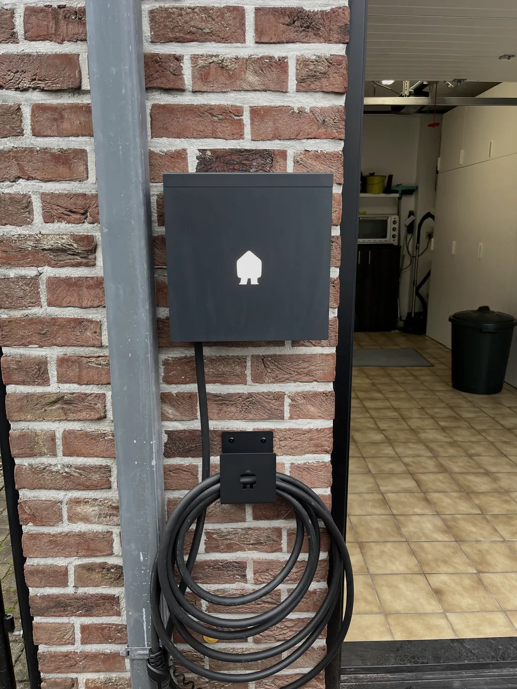 zwarte laadpaal aan carport met terras, geplaatst door Wattra