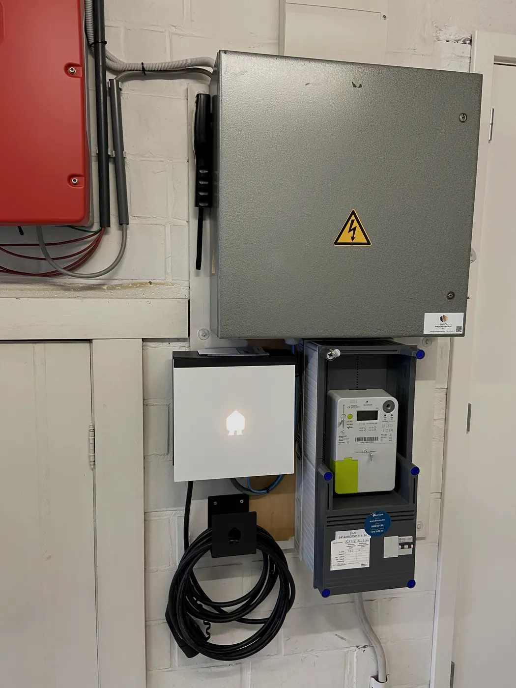 laadpaal met aparte digitale meter in technische ruimte, geplaatst door Wattra