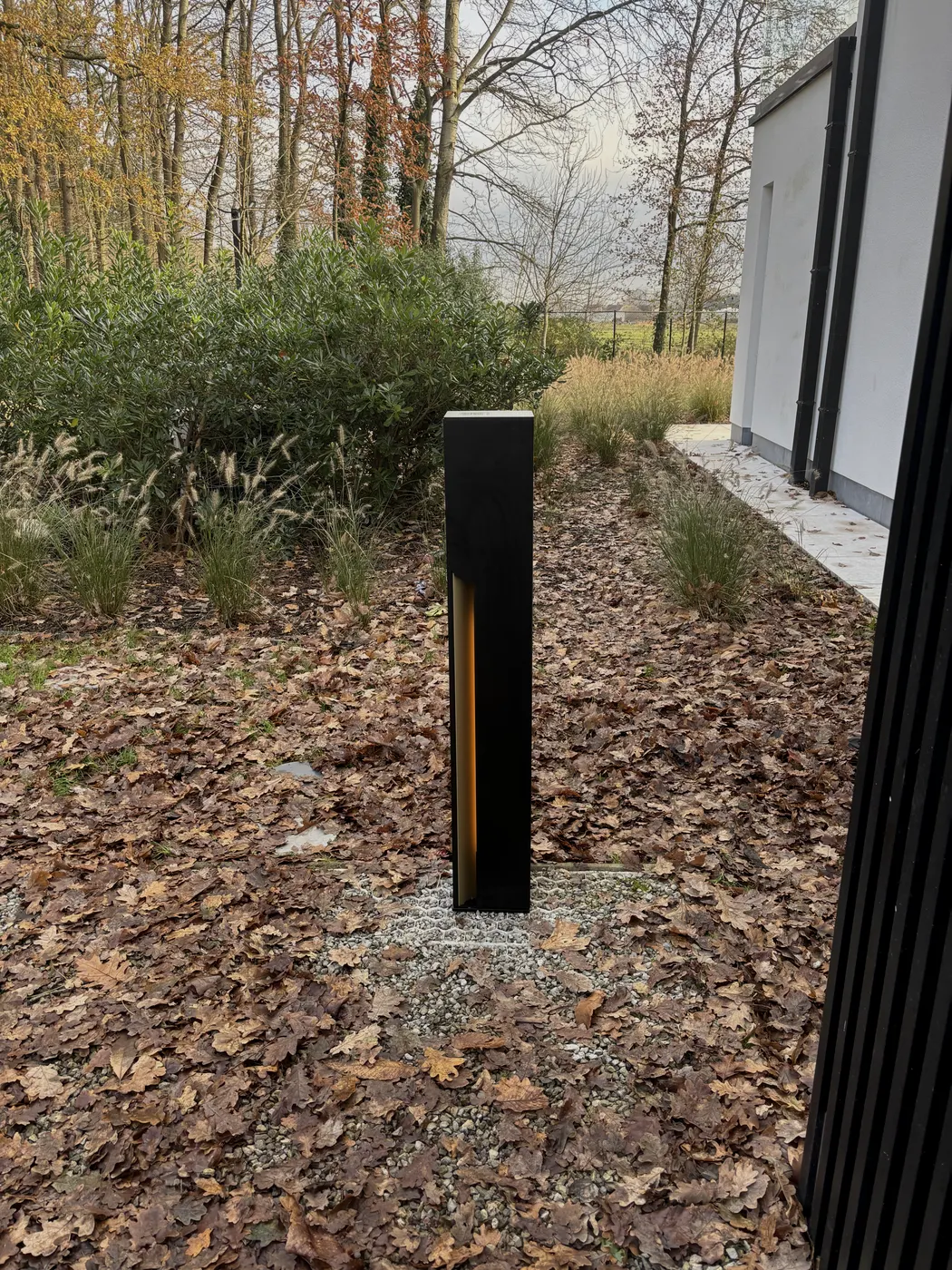 Veton laadpaal met verlichte laadstrip in aangelegde tuin, geplaatst door Wattra