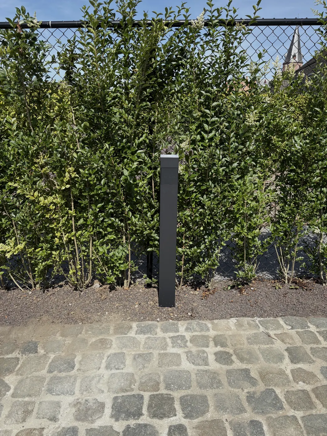 Smappee EV One laadpaal op zuil aan kasseienoprit, geplaatst door Wattra