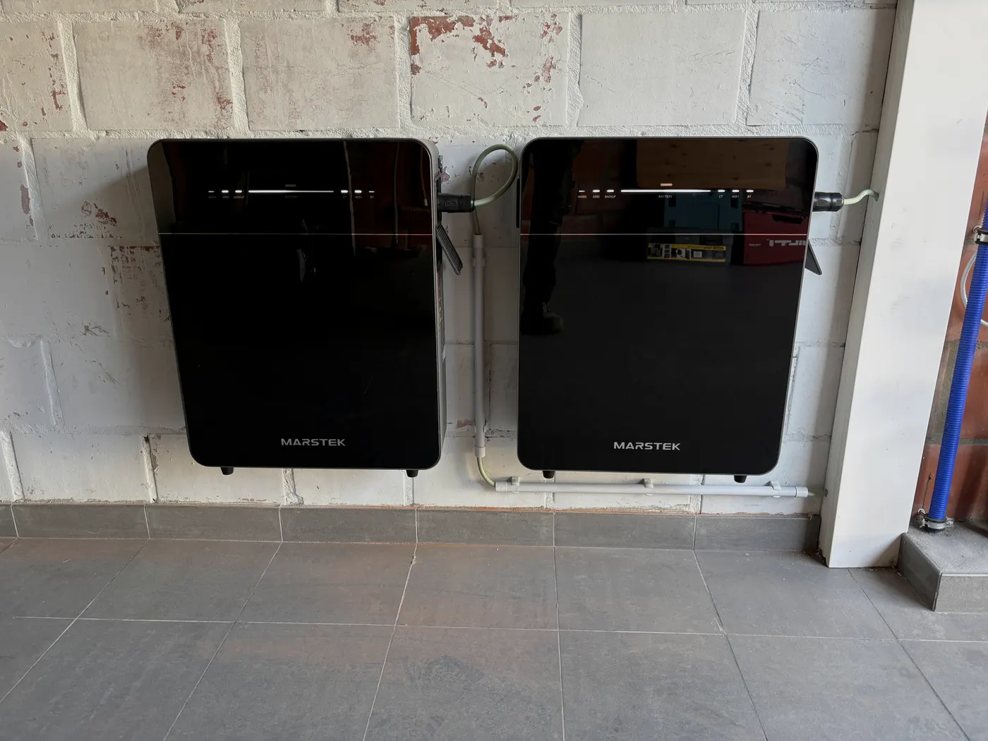 Twee zwarte Marstek thuisbatterijen naast elkaar aan muur, geplaatst door Wattra