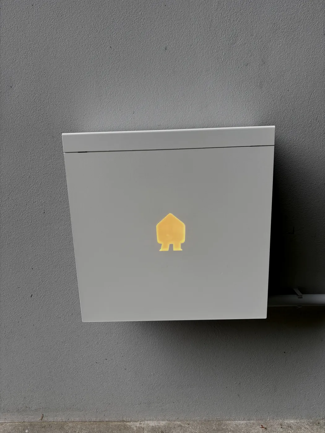 Close-up witte Smappee wallbox met gloeiend huisje-logo, geplaatst door Wattra