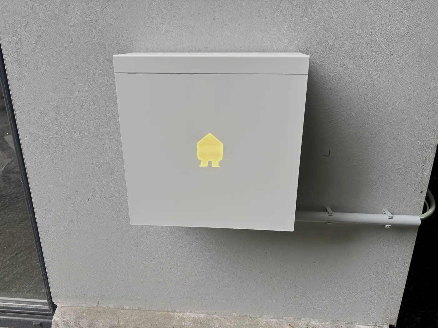 Smappee laadpaal frontaal met verlicht logo en kabelbuis, geplaatst door Wattra