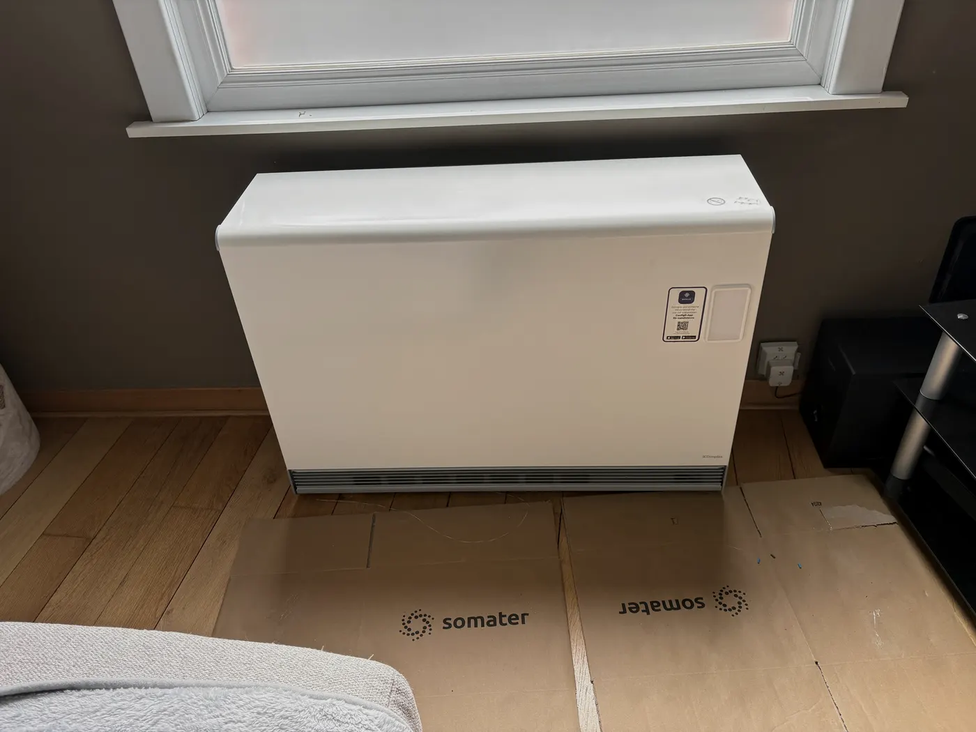 Witte accumulatieverwarming onder venster in woonkamer, geplaatst door Wattra