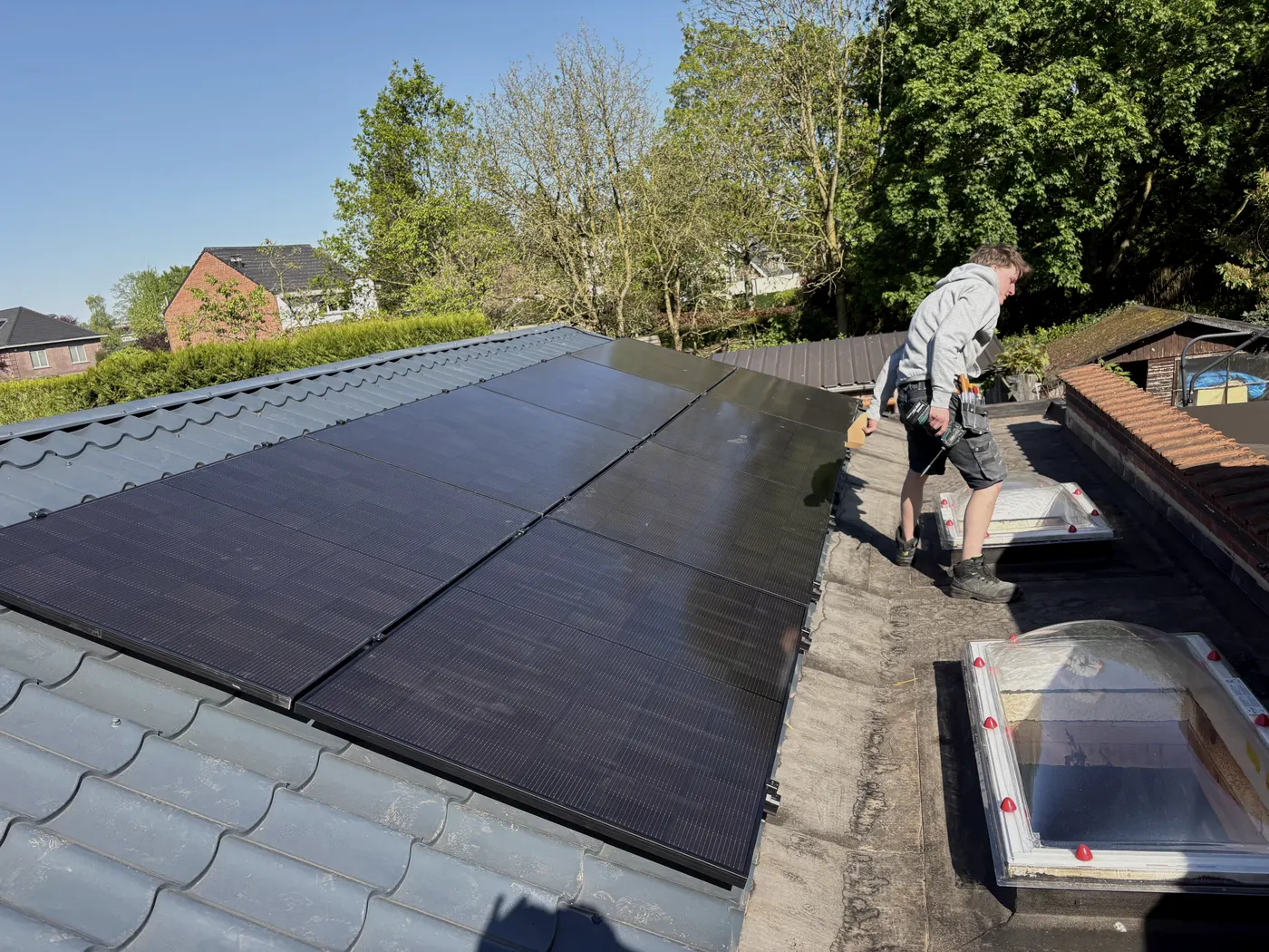 Installateur werkt aan zonnepanelen op dak, zonnig weer, geplaatst door Wattra