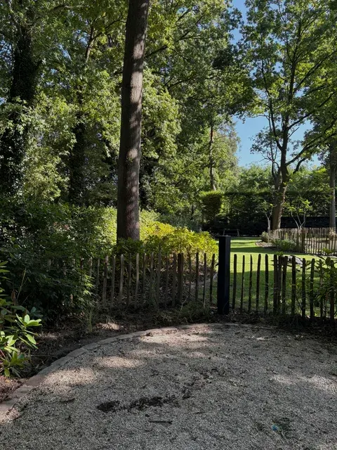 Smappee EV One laadpaal op zuil in tuin, geplaatst door Wattra
