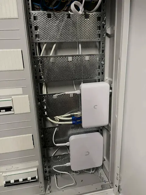 Datakast met patchpaneel en twee Ubiquiti netwerktoestellen, geplaatst door Wattra